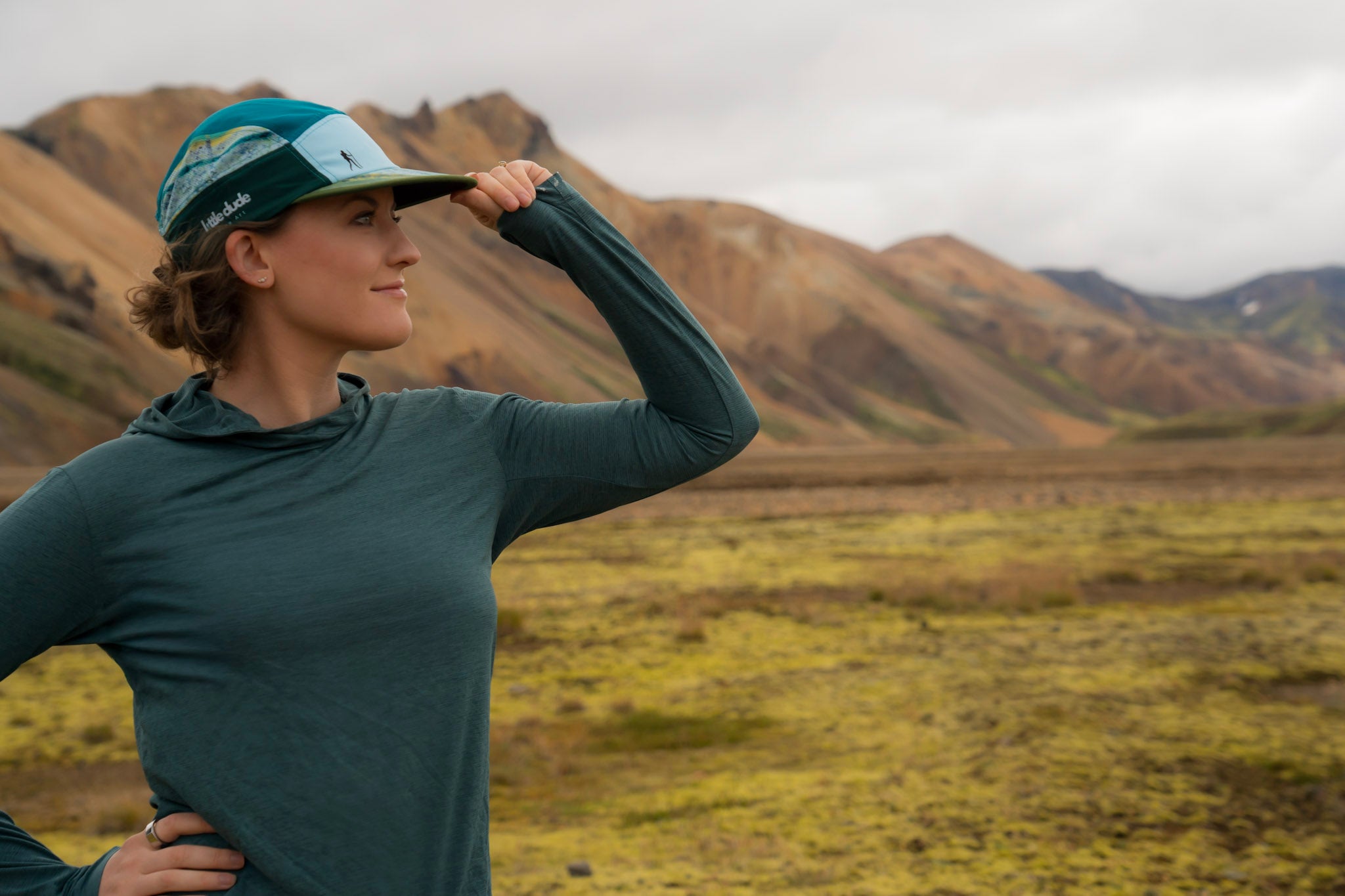 Person wearing a cap and long-sleeve shirt in a mountainous landscape